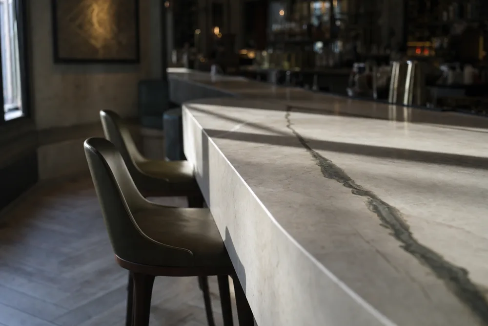 Pale stone bar counter in an empty cocktail bar before service